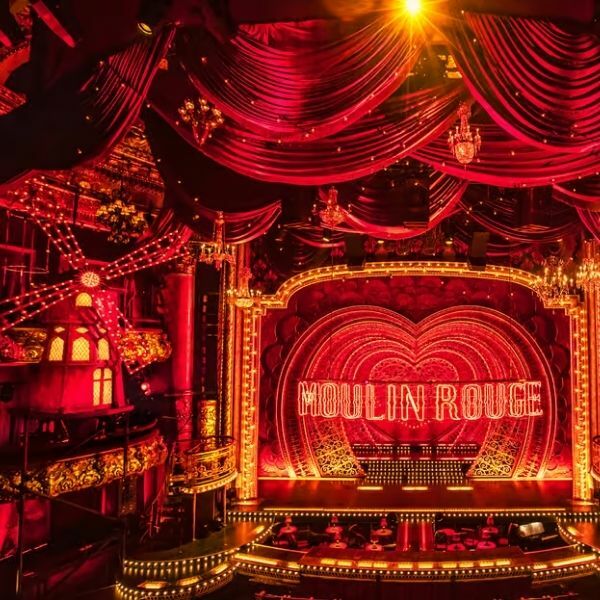 Cena do musical Moulin Rouge na Broadway, mostrando o elaborado cenário vermelho e dourado e os figurinos deslumbrantes deste espetacular musical da Broadway