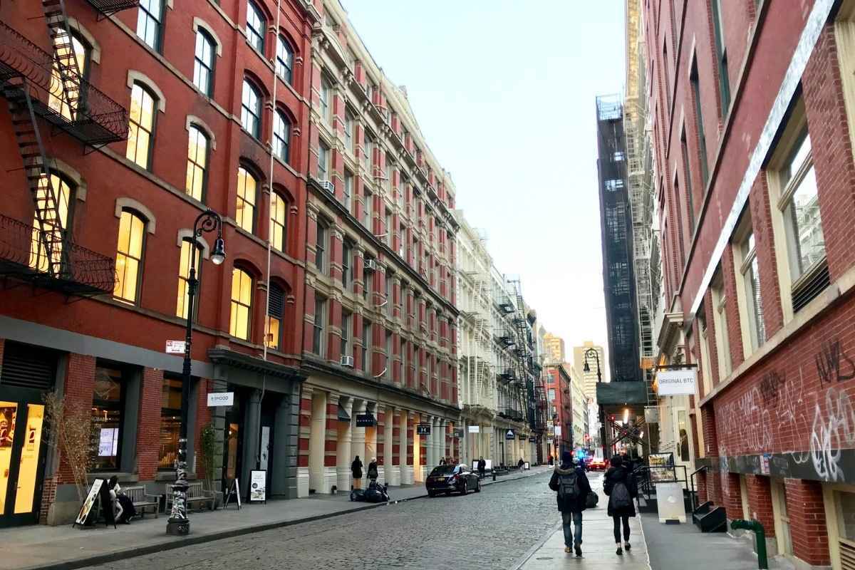 Fachadas de edifícios cast-iron e ruas de paralelepípedo no SoHo em Nova York
