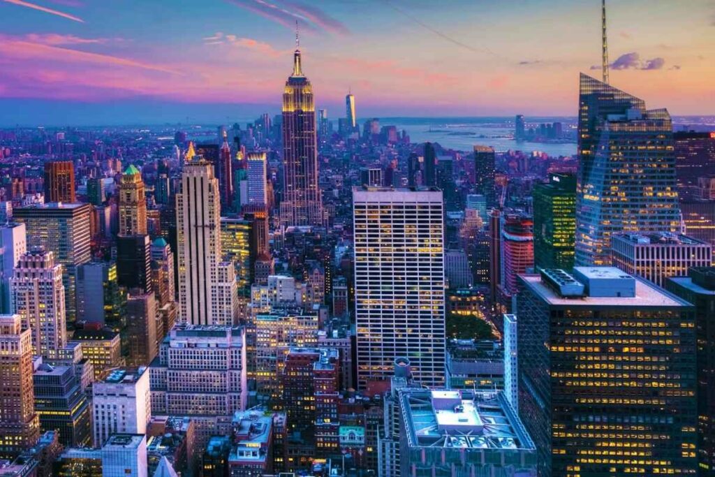 Vista noturna de Manhattan com luzes dos hoteis baratos de Nova York e arranha-céus iluminados