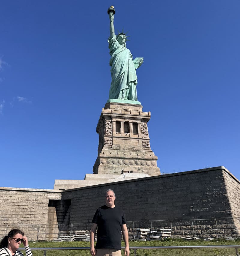 Robson aos pés da Estátua da Liberdade em dia de verão