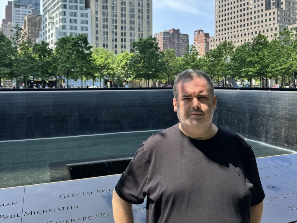 Foto autoral do pós-graduando em Turismo em frente à Piscina do Memorial 11/09, reforçando a experiência e o tom respeitoso da visita.