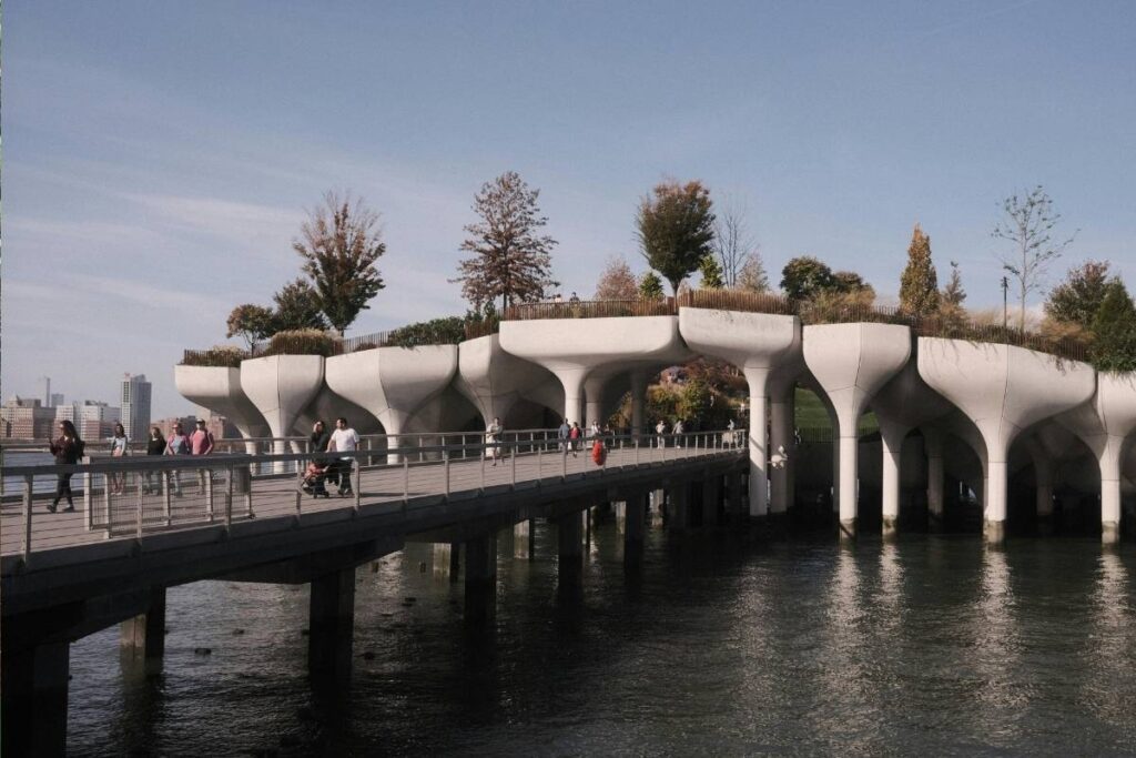 Little Island com suas estruturas únicas sobre o rio Hudson, pessoas aproveitando o local, e ao fundo a silhueta da cidade de Nova York